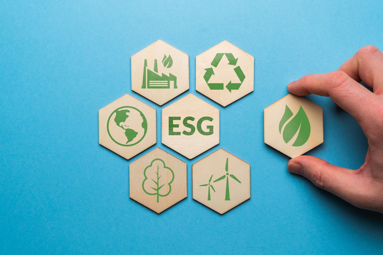drewniane tabliczki symbolizujące zakres ESG na niebieskim tle