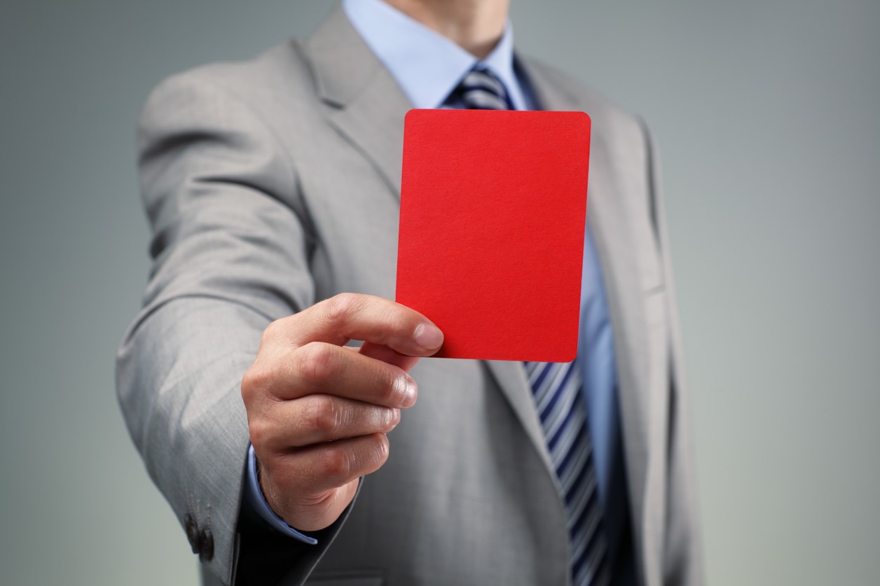 przedsiębiorca trzyma w dłoni czerwoną kartkę