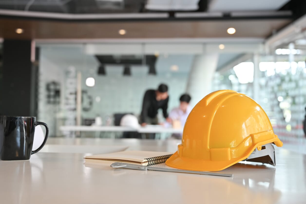 kask symbolizujący działalność regulowaną na biurku