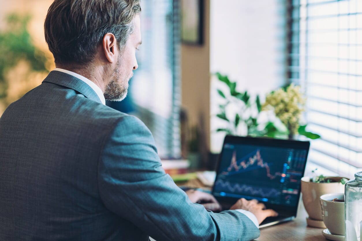 przedsiębiorca analizuje wykresy z danymi na laptopie
