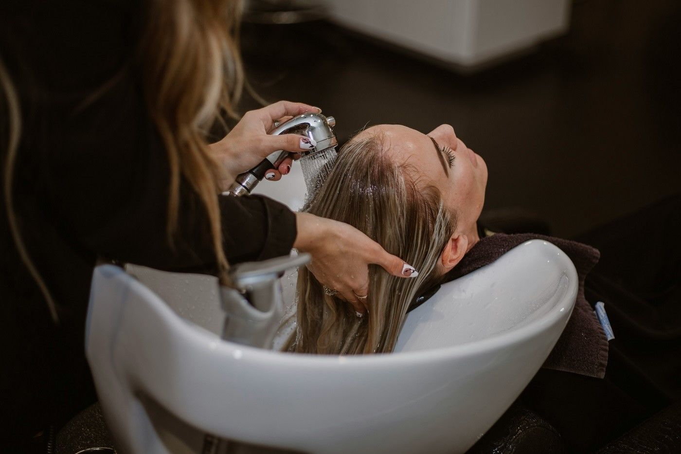 fryzjerka myje włosy klientce